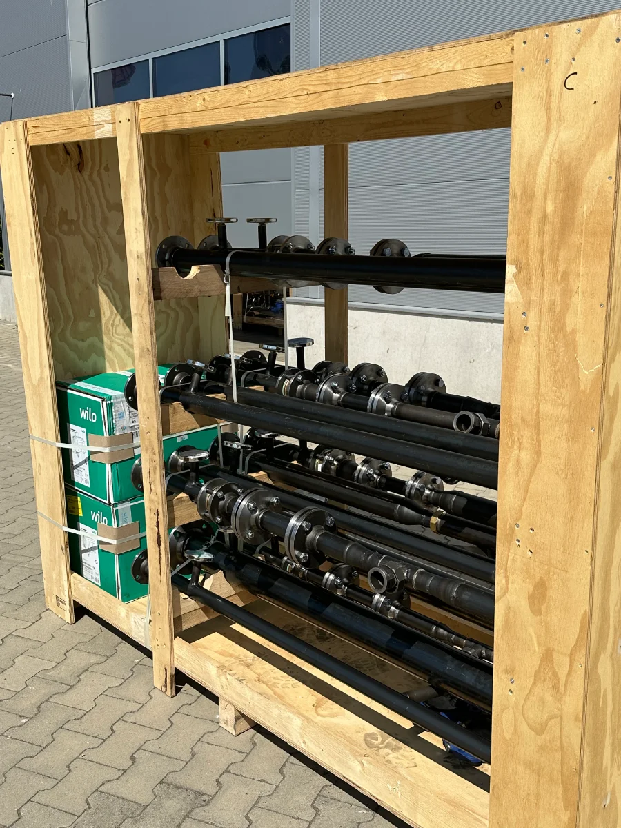 Holz-Transportbox mit gelagerten solus Rohrverteilern und Komponenten auf einem Betriebshof. Das Bild steht für das nachhaltige Recycling- und Rückgabesystem von solus.